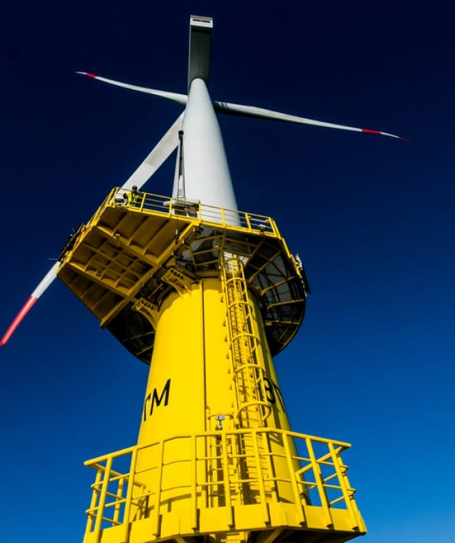 A yellow wind turbine with a ladder on top