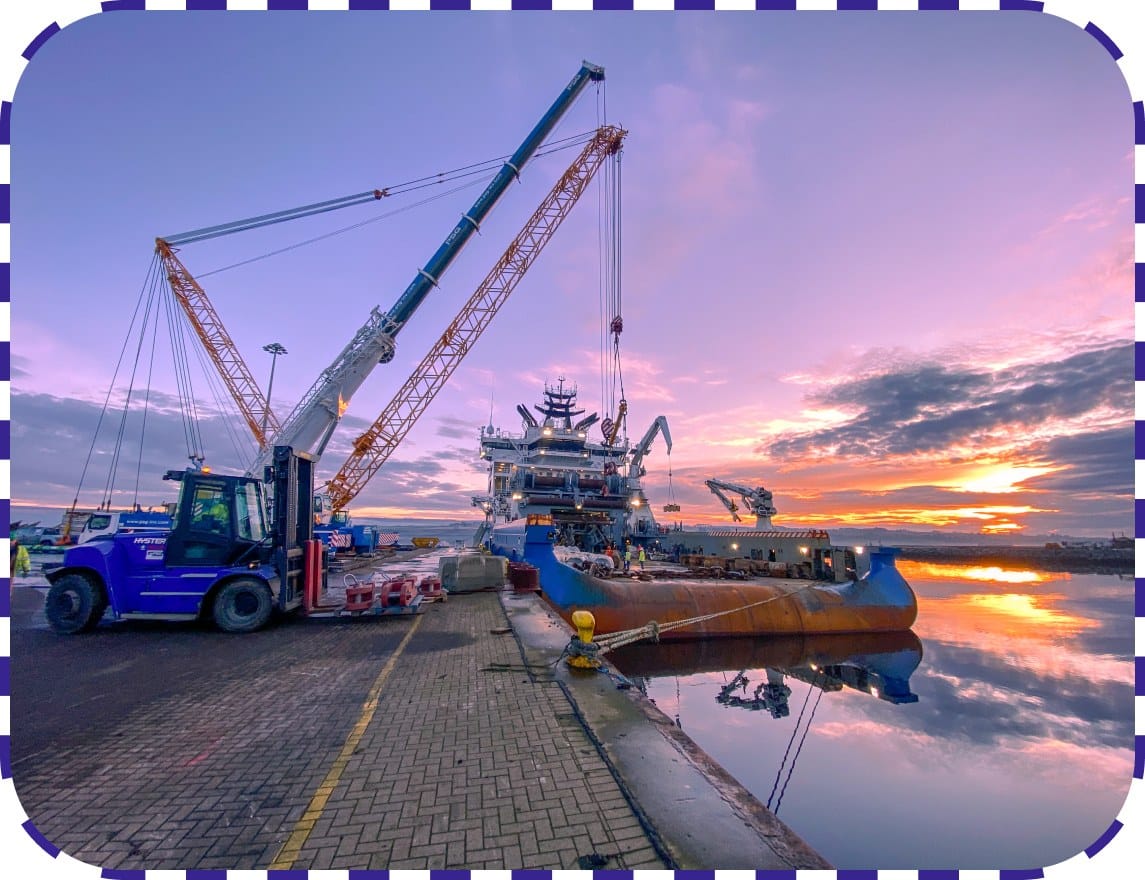 Crane operating at quayside near shipping containers