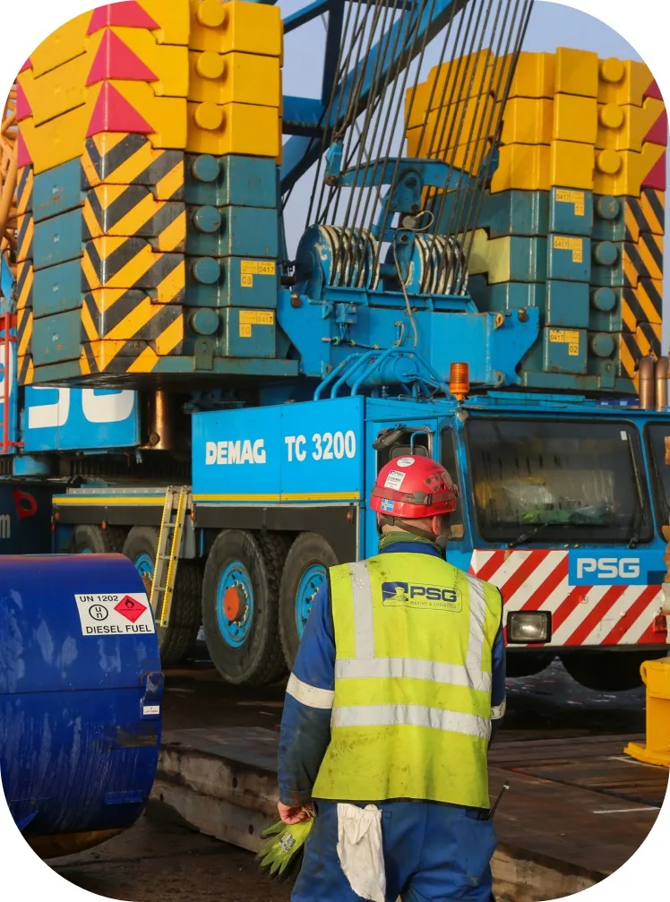 Side view of crane hoisting heavy load during lifting operation