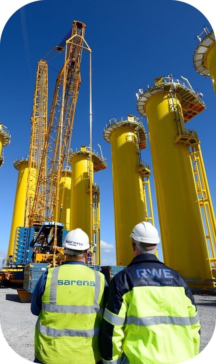 Workers operating crane lifting machinery on site