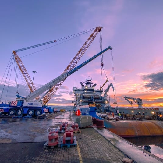 Multiple cranes positioned at quayside for port operations