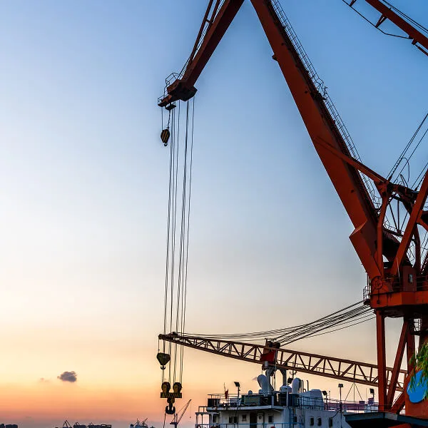 Crane lifting load at industrial site
