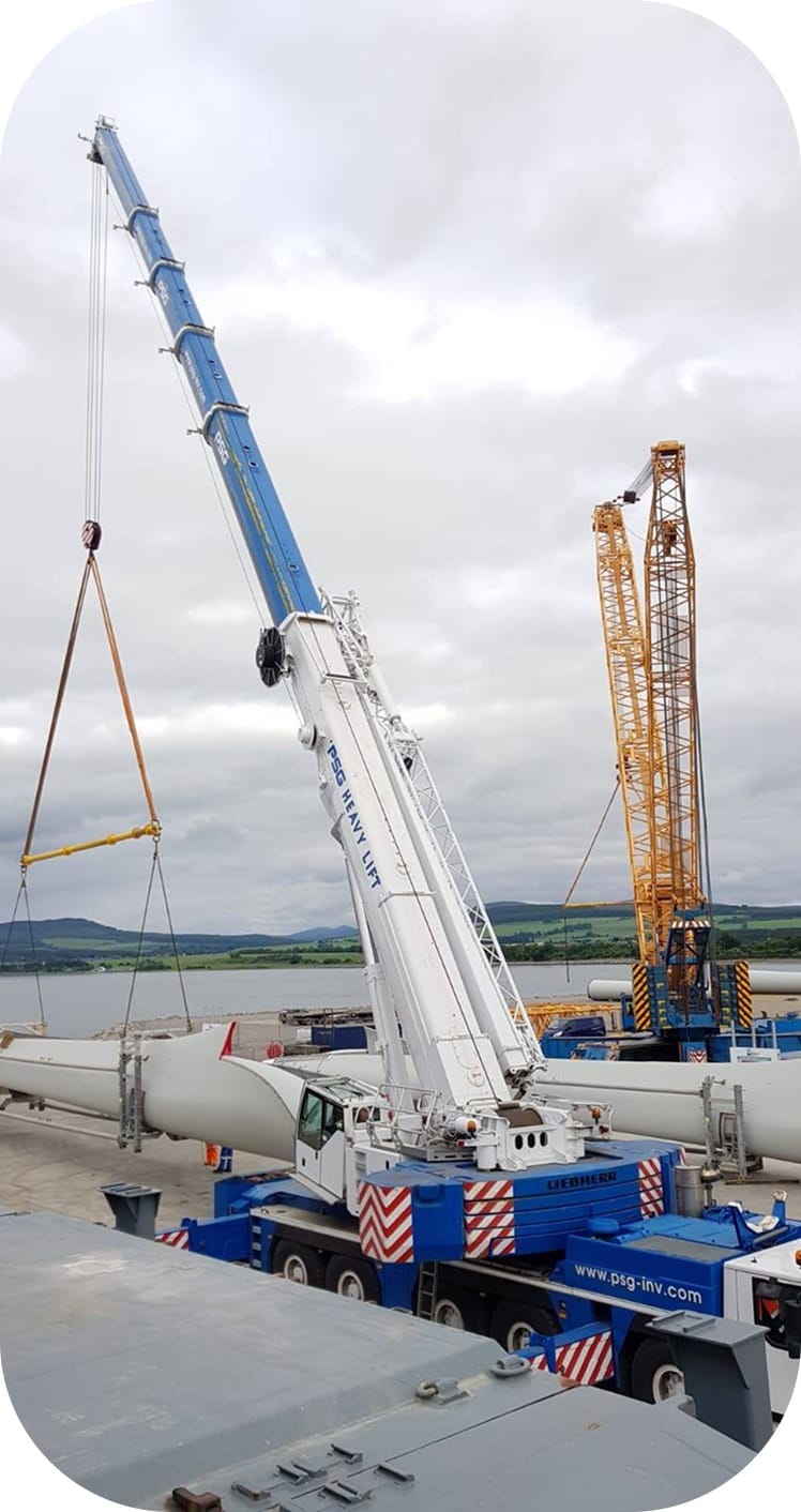 A crane hoisting a large metal piece
